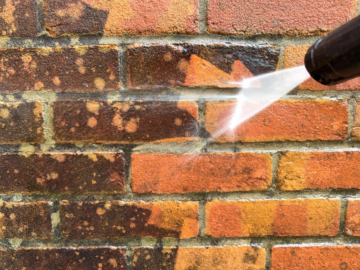 Pressure washer in use cleaning a wall — pressure washer repair in Maple Valley WA